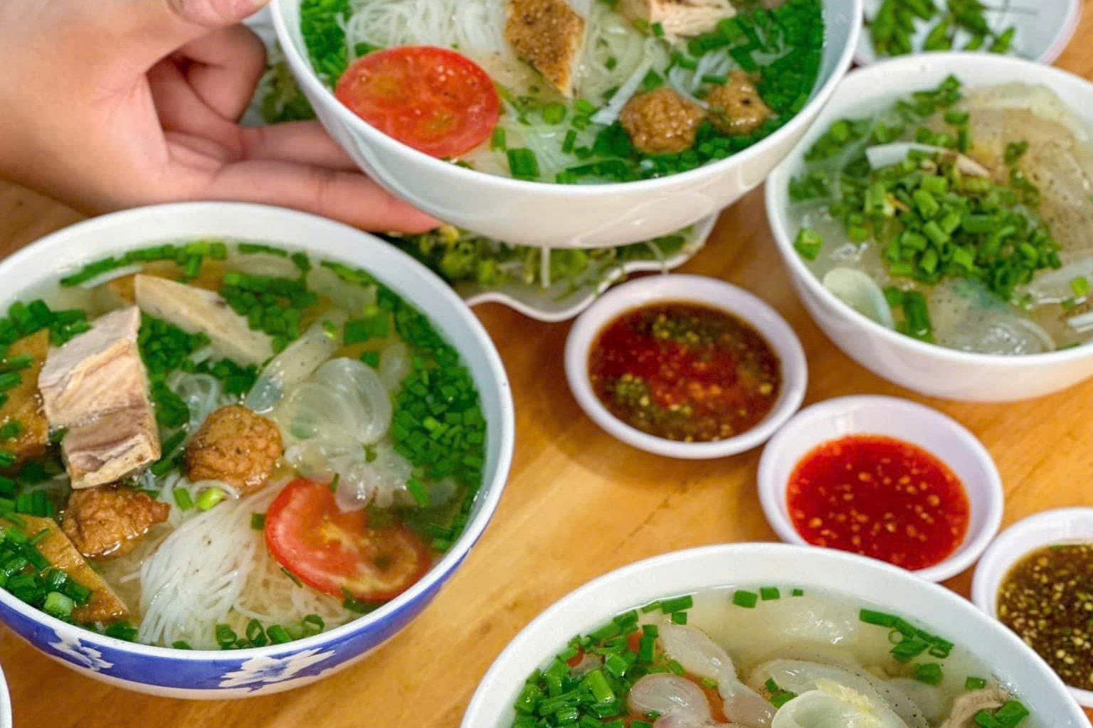 Những tô bún cá với chả cá, sứa, cà chua và các chén nước chấm ở Quán Bún cá Mịn