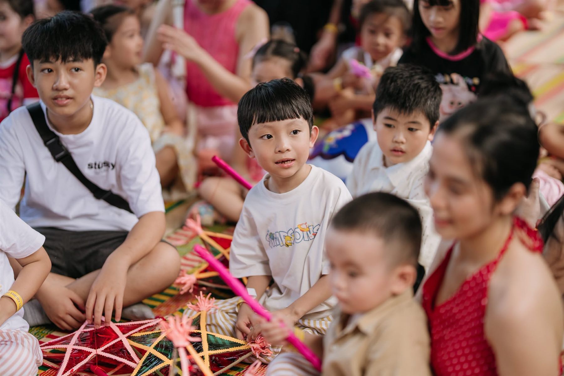 Trẻ em ngồi trên chiếu cùng những chiếc đèn ông sao ở Làng nghề Nha Trang Xưa